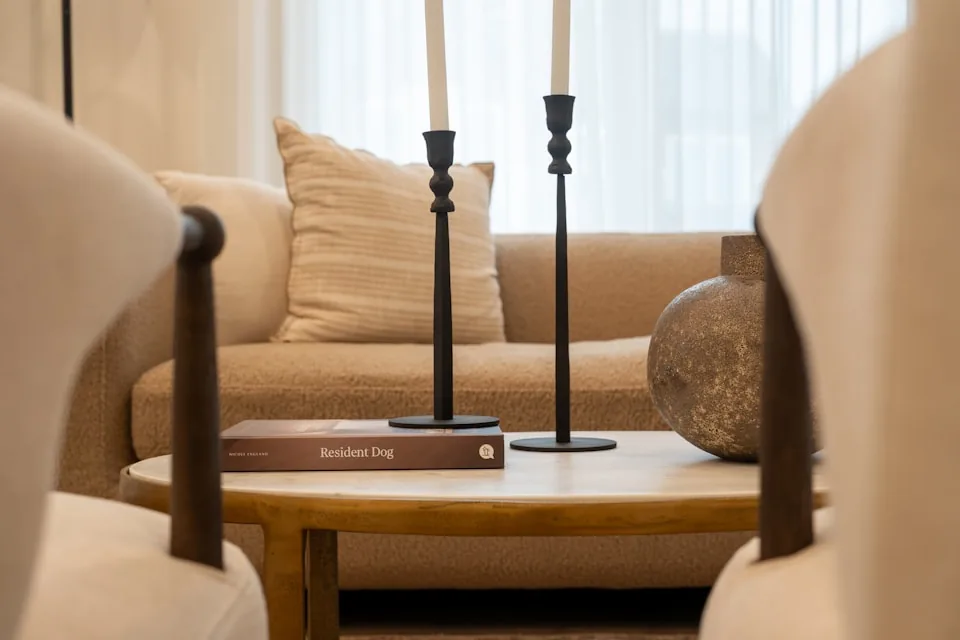 Une table basse, un livre et deux bougeoirs dans un salon.